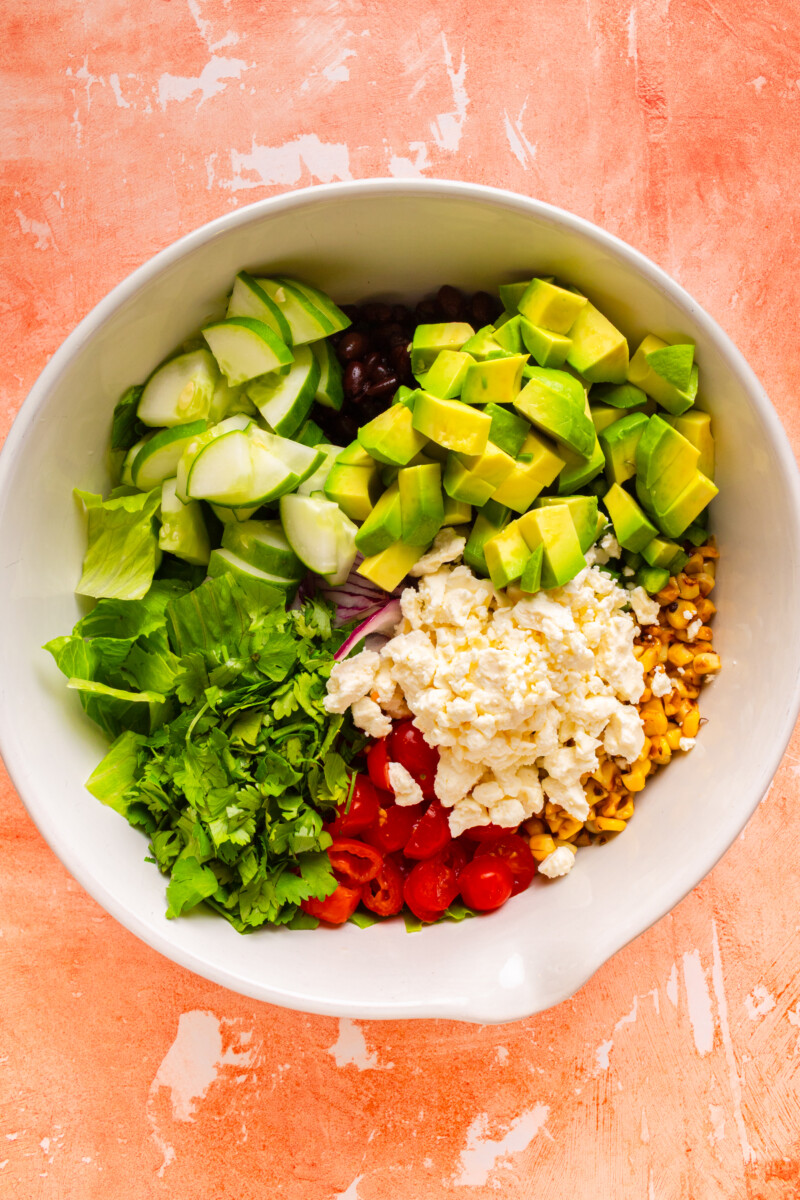 All ingredients for the salad added to a salad bowl.