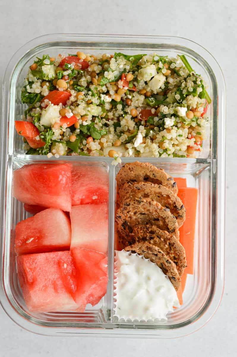 Serving Costco quinoa salad with watermelon, cheese and crackers in an adult lunchable.