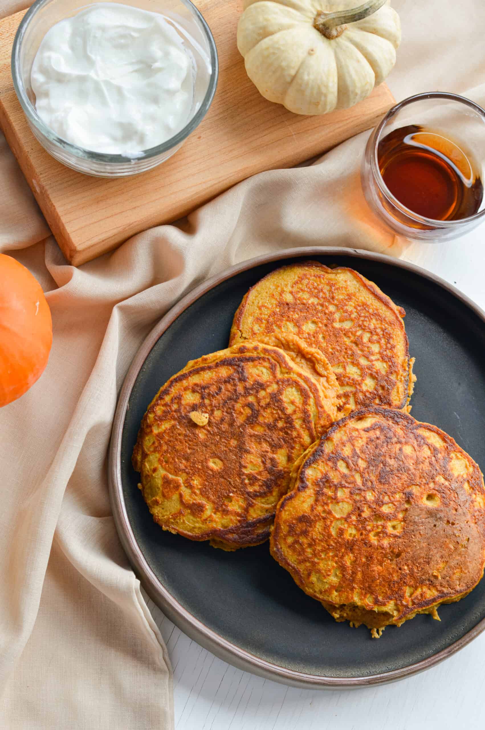 Birds eye view of pumpkin blender pancakes served with maple syrup.