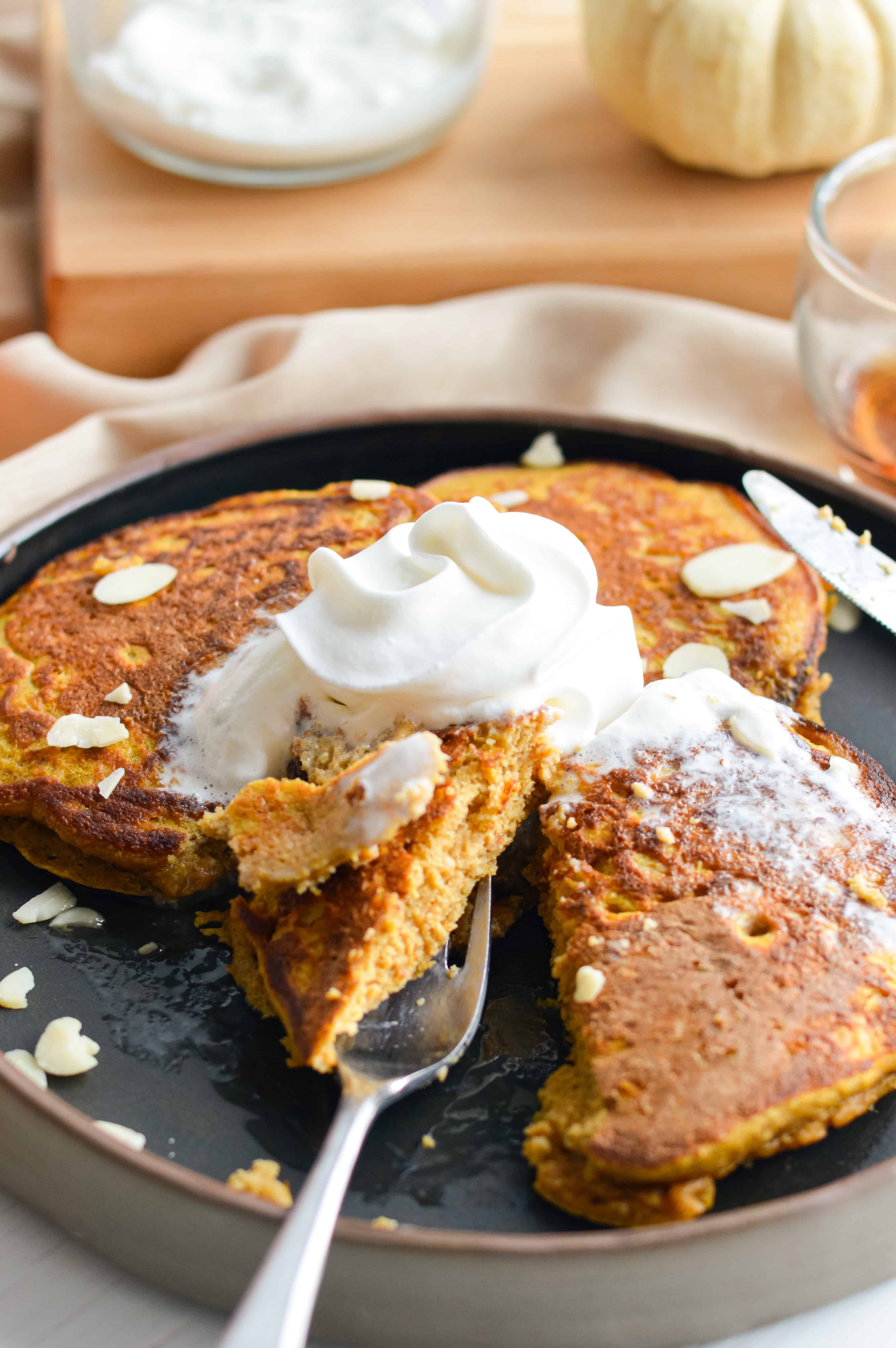 Pumpkin protein pancakes served with whipped cream.