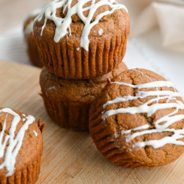 Healthy gingerbread muffins stacked on a board.