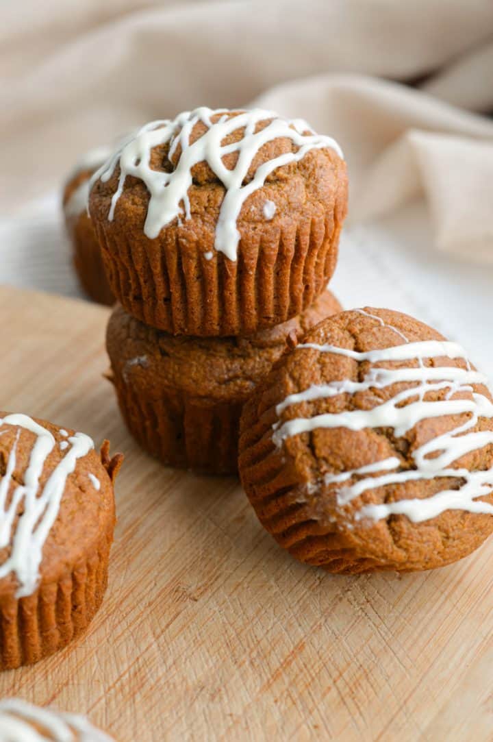 Healthy gingerbread muffins stacked on a board.