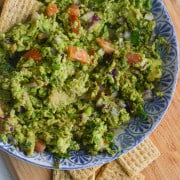 Edamame guacamole in a bowl with crackers.