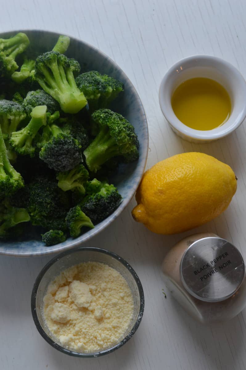 Ingredients for air fryer frozen broccoli including lemon, parmesan and olive oil.