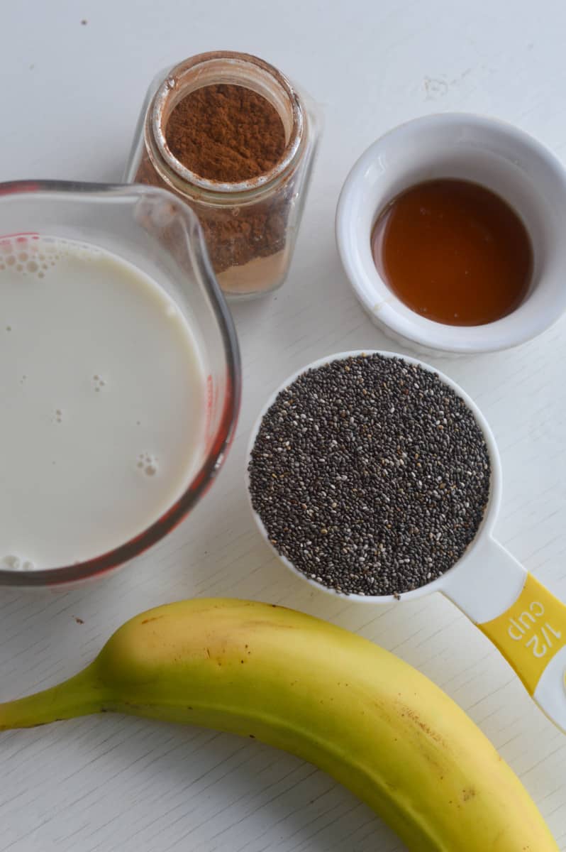 Ingredients for warm chia pudding, including chia seeds, banana, milk and cinnamon.