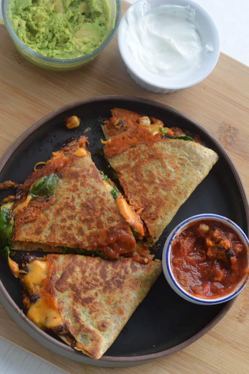 Air fryer quesadillas served with salsa, guacamole and sour cream.