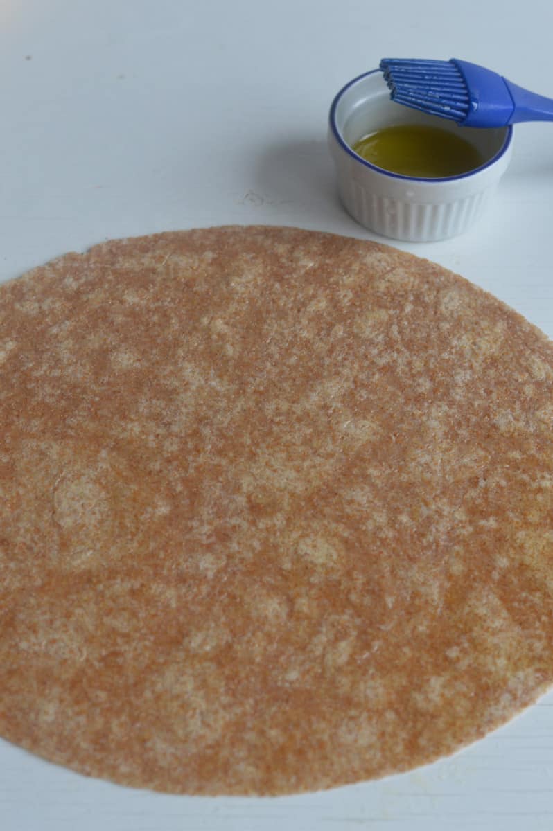 Brushing a tortilla with olive oil.