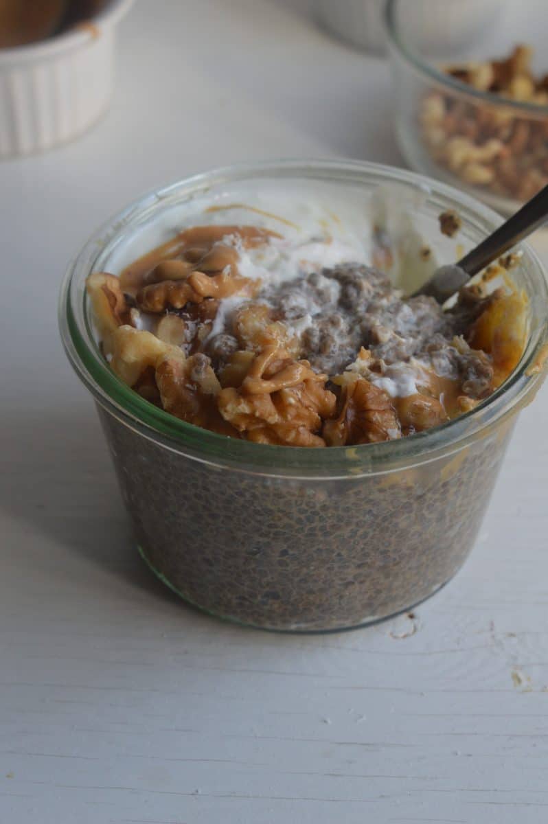 Warm chia pudding in a glass jar with toppings.