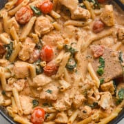 Creamy chicken and tomato pasta in a pan.