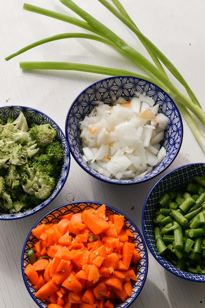 Ingredients for fried rice including onions, vegetables, and green onions.