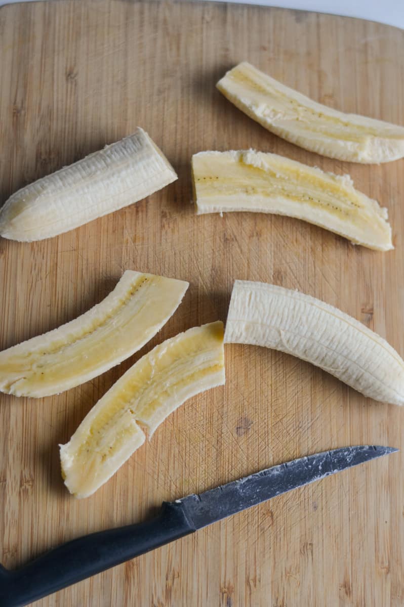Slicing bananas in half lengthwise.