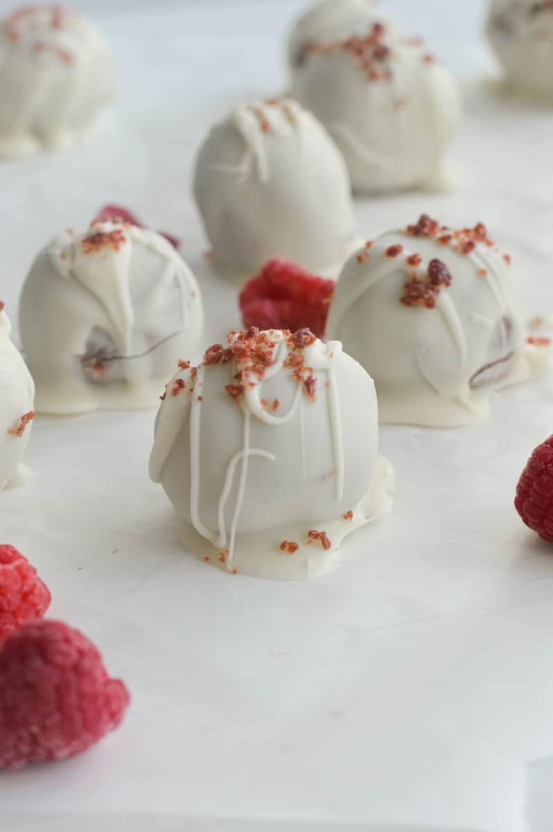 Close up of white chocolate raspberry truffles on a tray.