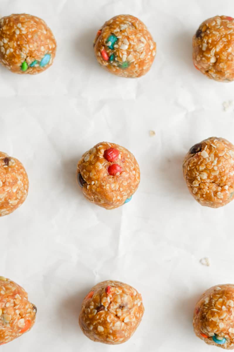 Rolling out 3 ingredient peanut butter oatmeal balls on a tray.