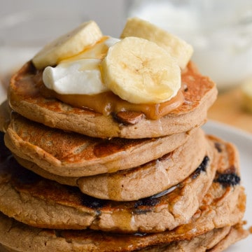 Stack of 3 ingredient protein powder pancakes, topped with greek yogurt and banana.