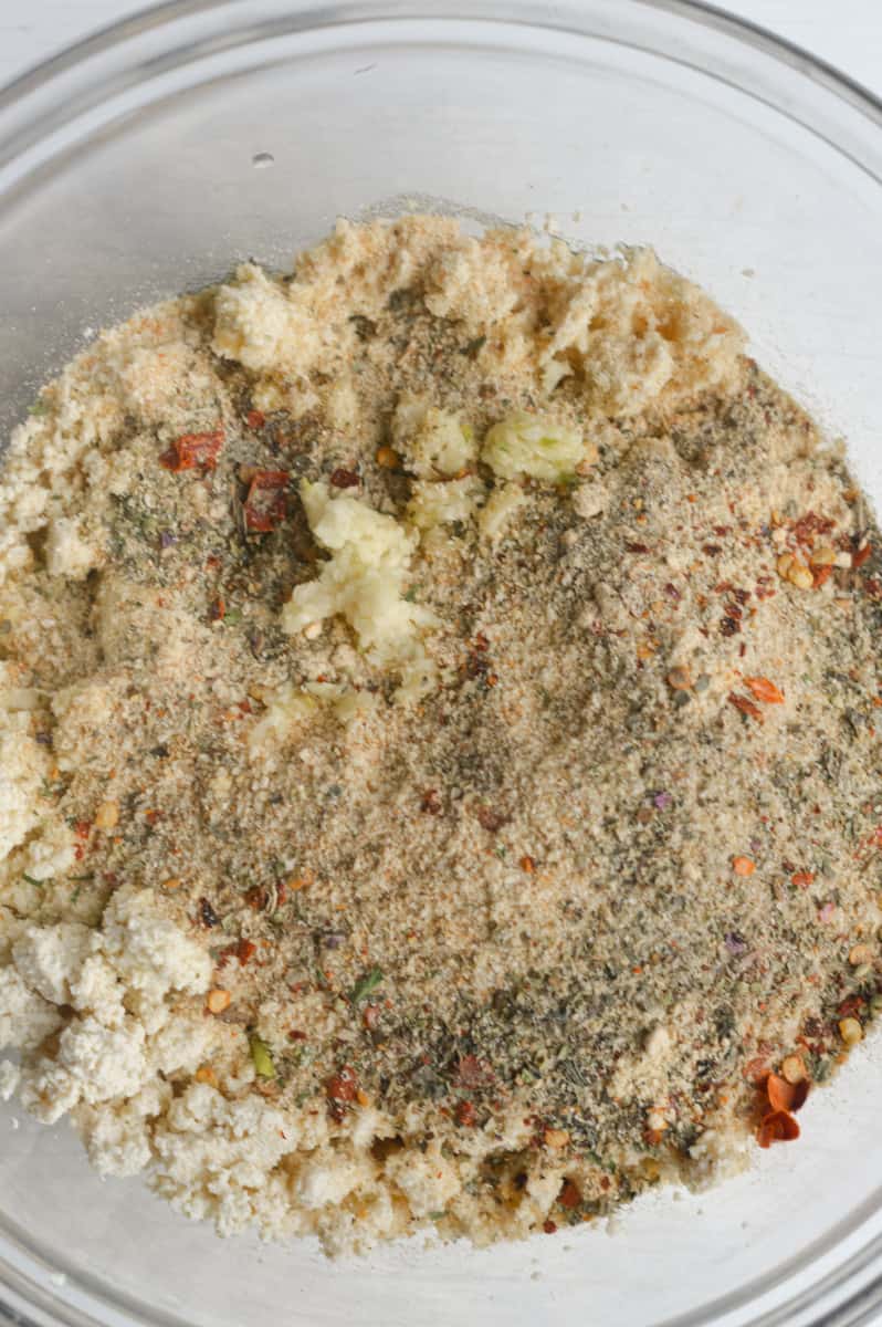Adding spices and breadcrumbs to crumbled tofu.