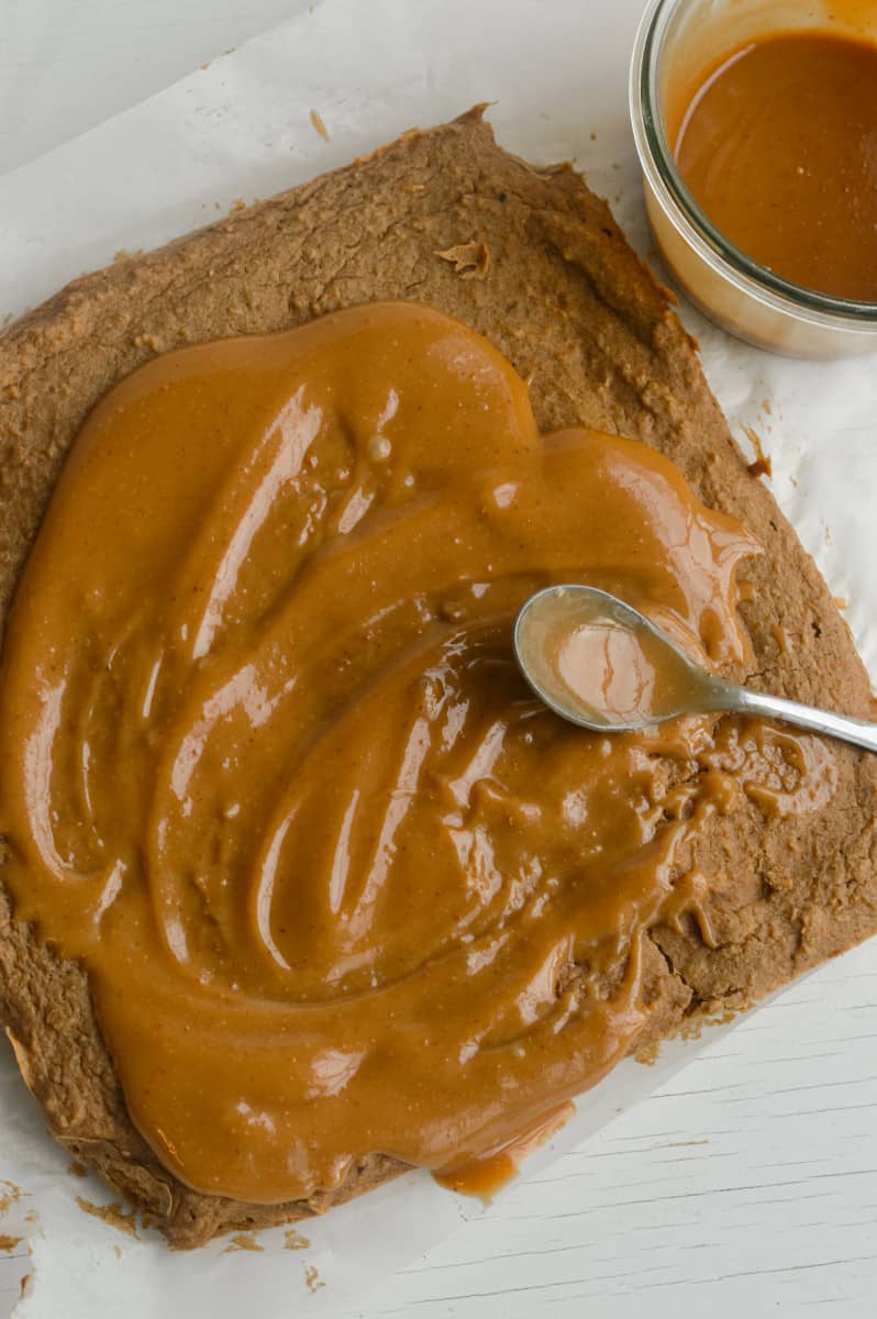 Frosting chickpea blondies with vegan salted caramel.