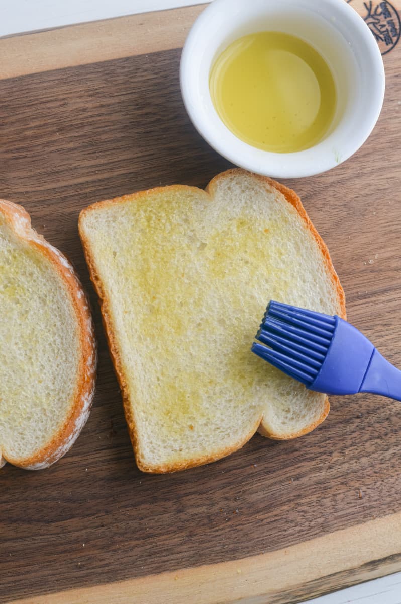 Brushing olive oil on bread.