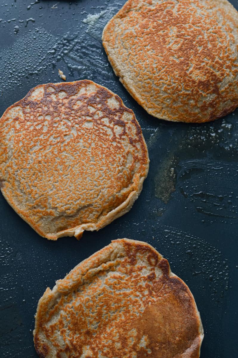 Flipping pancakes on a griddle.