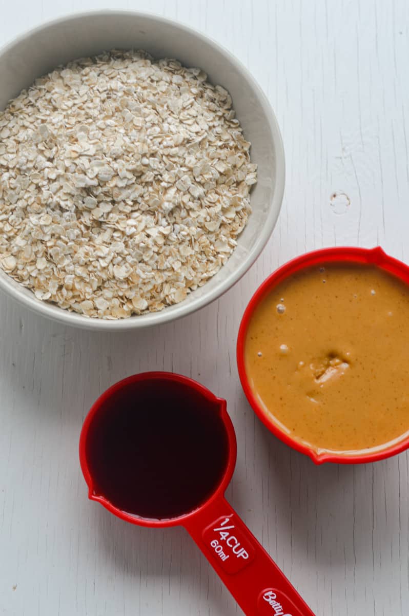 Ingredients for 3-ingredient peanut butter oatmeal balls including peanut butter, oats and maple syrup.