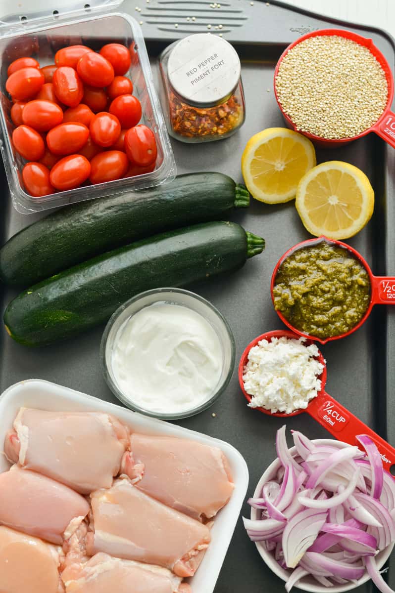Ingredients for pesto chicken quinoa bowls on a pan.