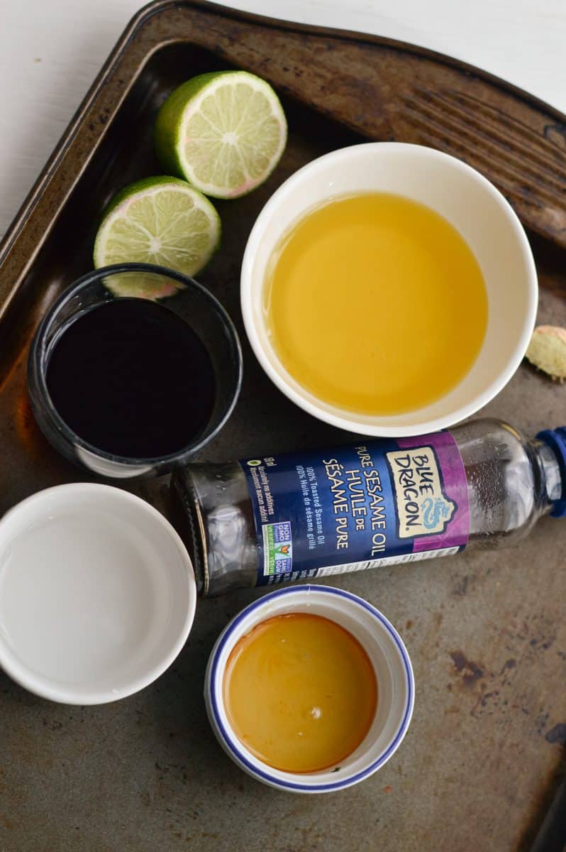 Ingredients for sesame ginger lime dressing including vinegar, honey, olive oil and sesame oil.