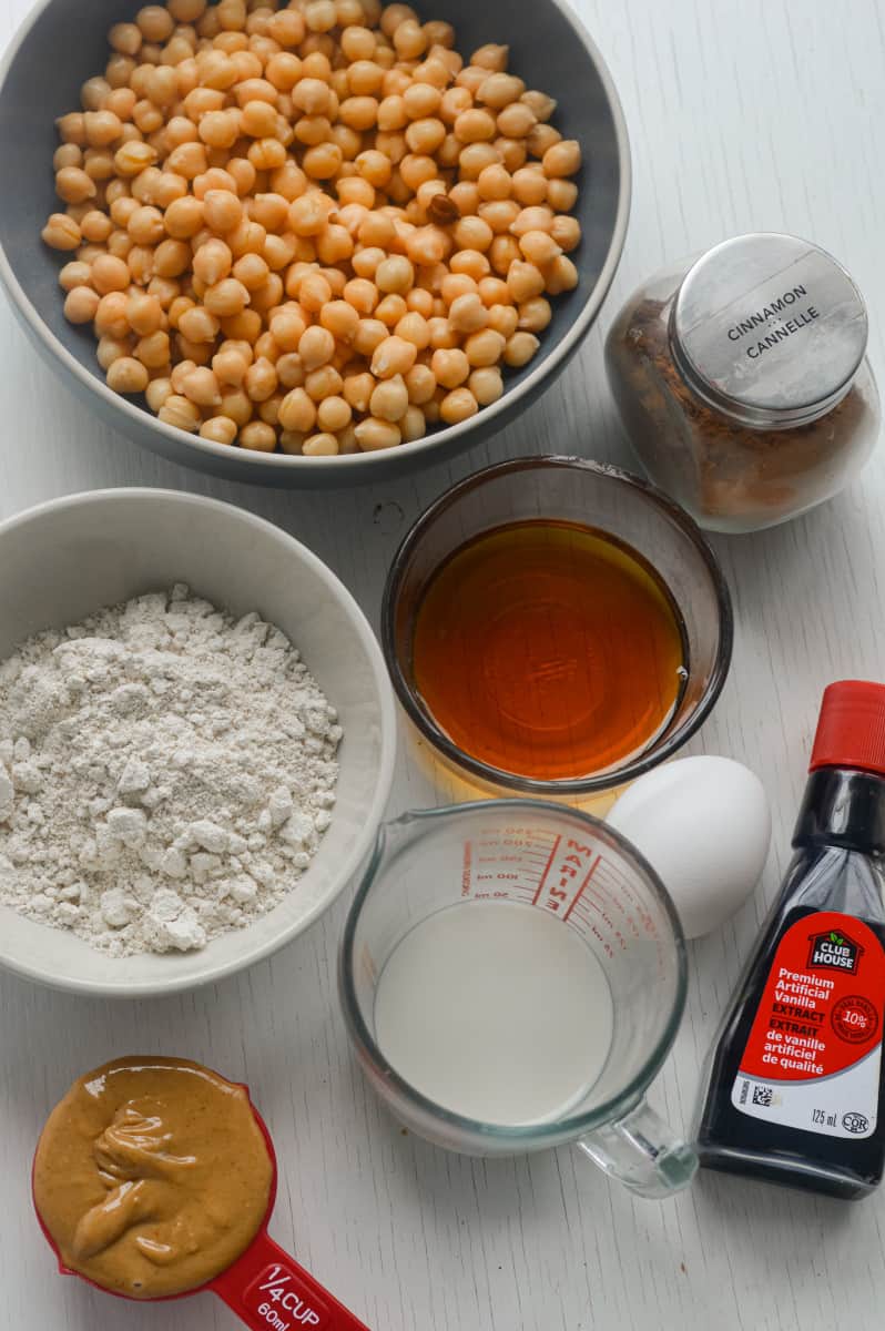 Ingredients for chickpea blondies including flour, eggs, milk, chickpeas, and peanut butter.