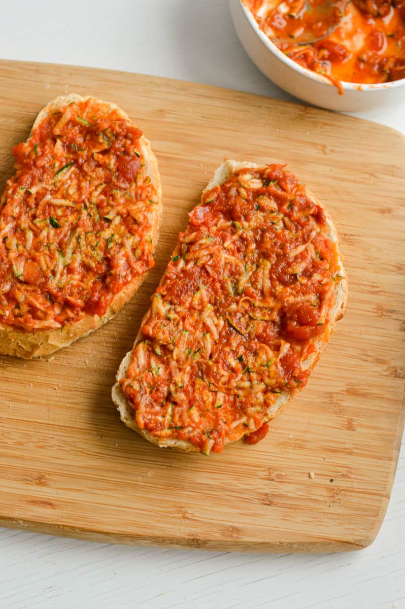 Spreading tomato sauce on bread.