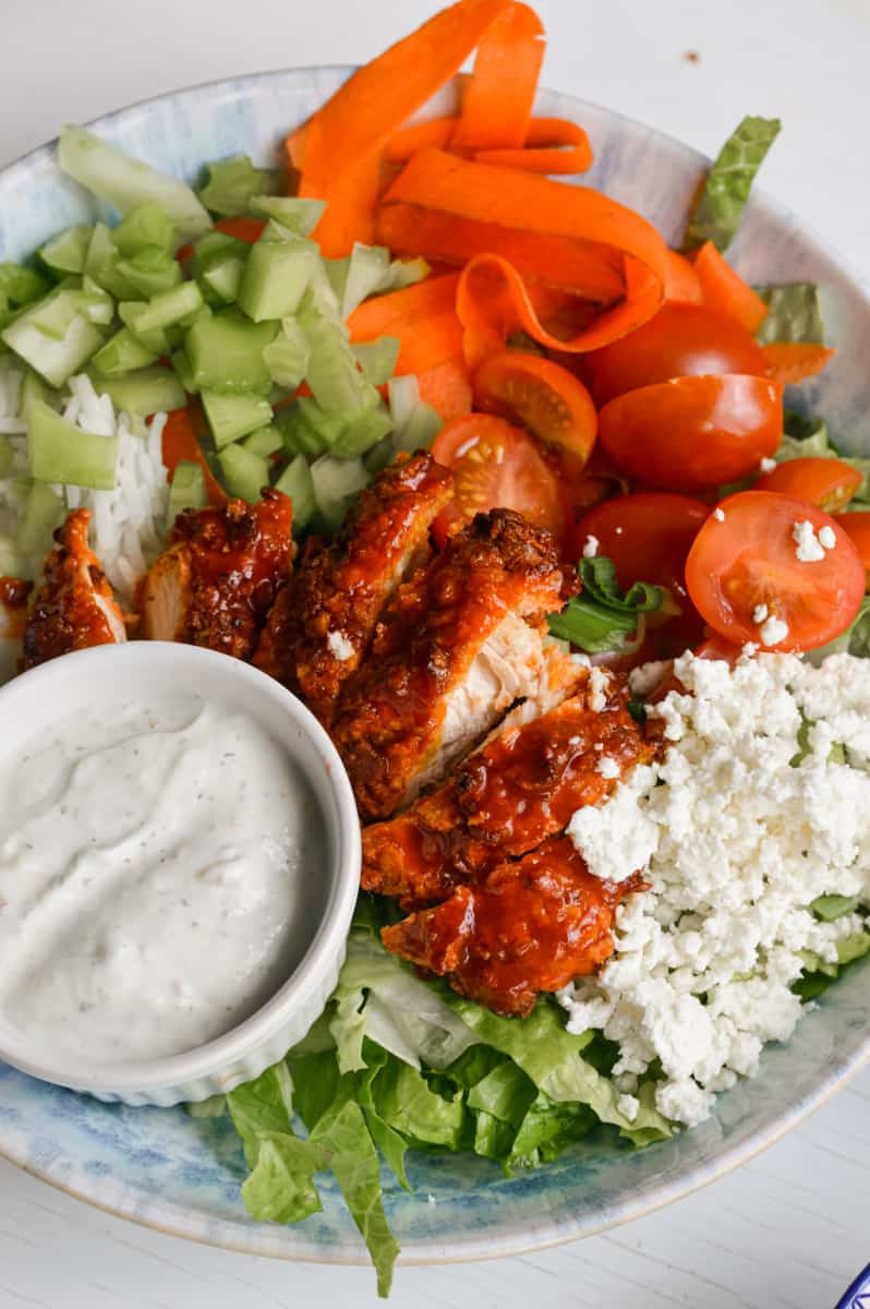 Close up of buffalo chicken bowls served with ranch dressing.