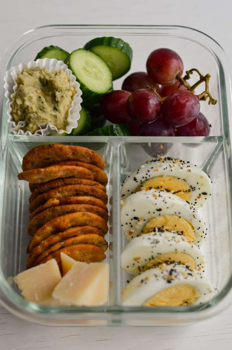 Snack plate idea with dip, grapes, cucumbers, crackers, cheese and boiled eggs.