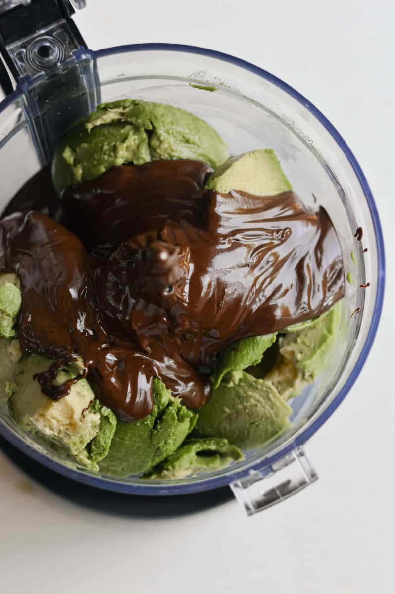 Melted chocolate poured over avocados in a food processor.