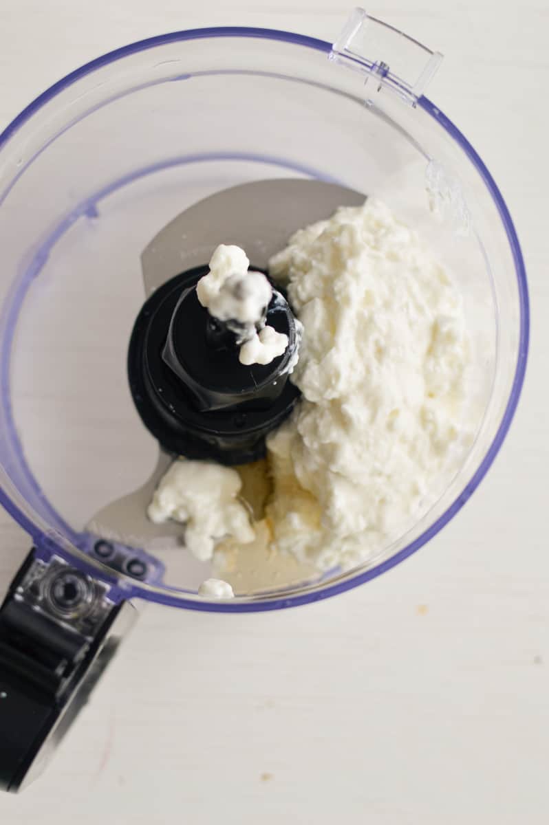 Adding cottage cheese to a food processor.