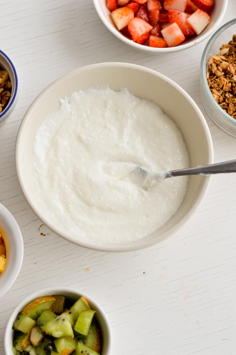 Adding toppings to blended cottage cheese bowls.