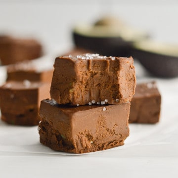 Two pieces of avocado fudge stacked, with a bite in the top piece.