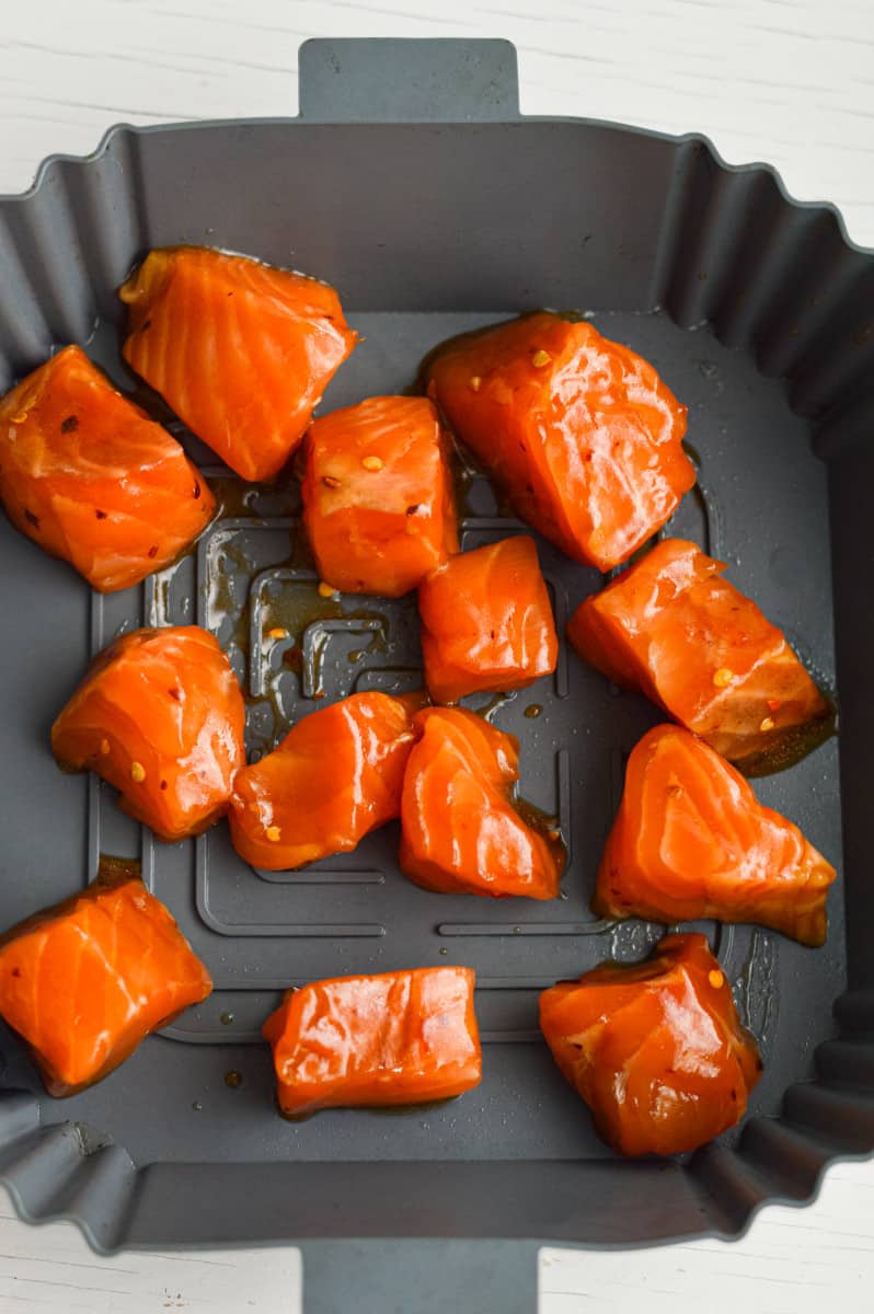 Putting salmon bites in the air fryer.