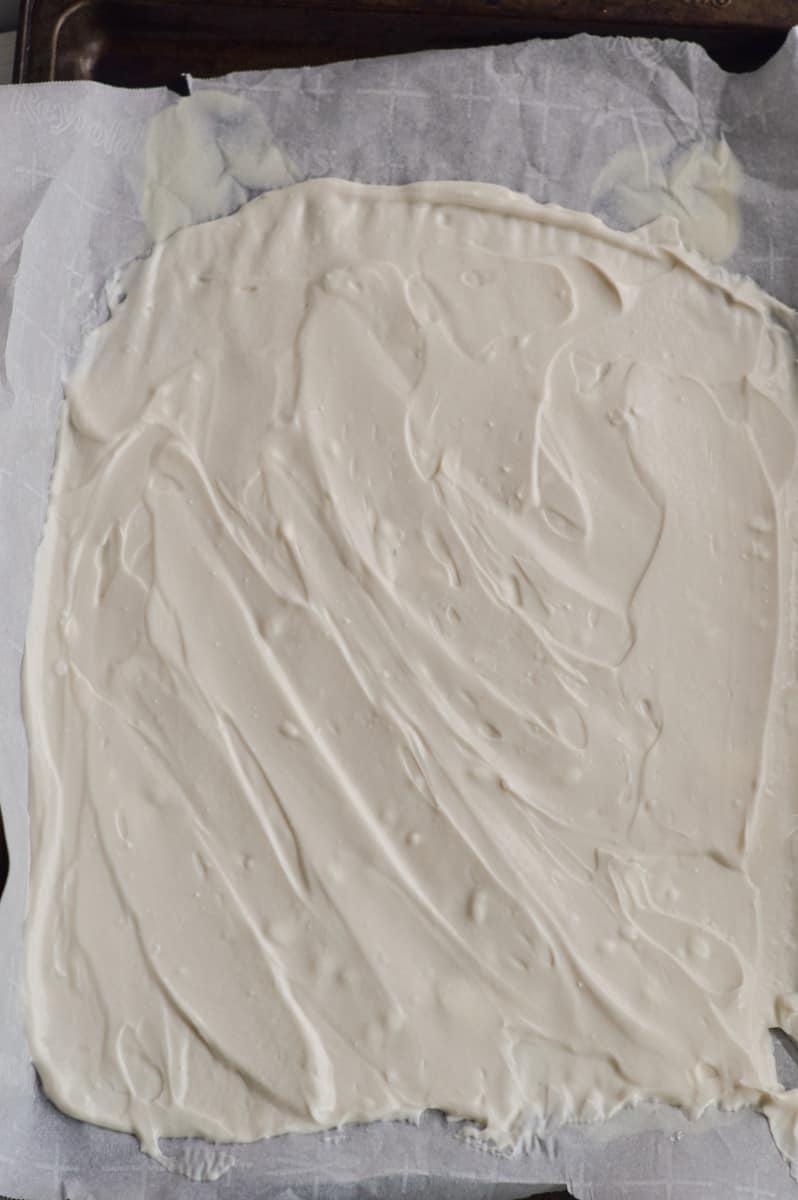 Spreading greek yogurt mixture on a baking sheet.