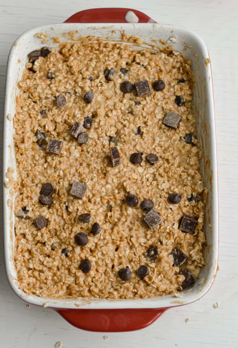 Sprinkling chocolate chips on top of oatmeal bars.