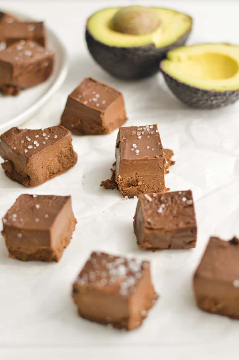 Squares of fudge with avocado in the background.