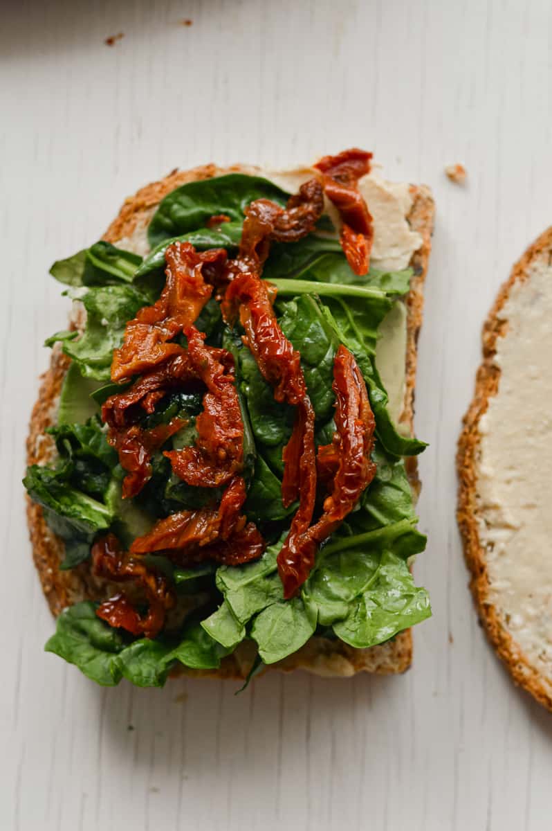 Adding spinach and sundried tomato to bread.