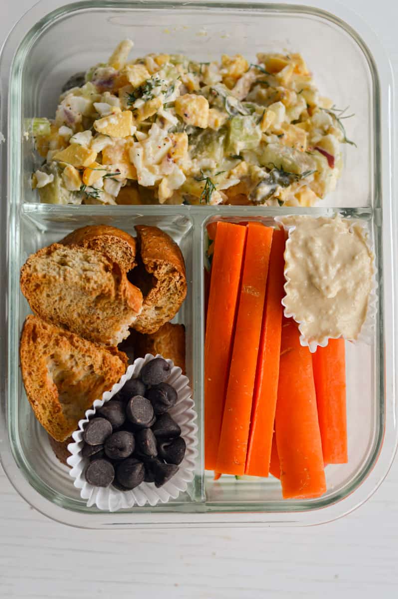 Serving egg salad with pickles in an adult lunchable.