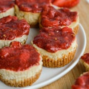 Mini protein cheesecakes topped with chia jam on a plate.