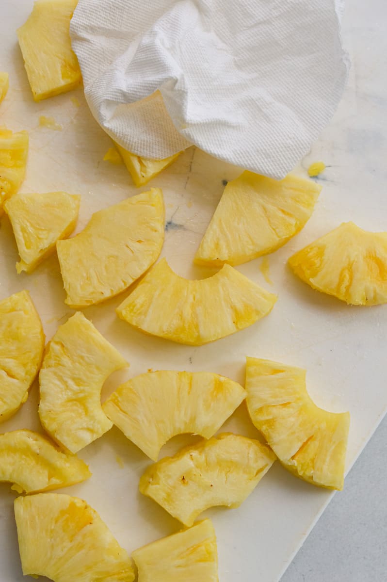 Slicing pineapple into wedge shaped pieces.