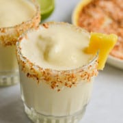 Healthy pina colada mocktail wiht a slice of pineapple and toasted coconut rim.