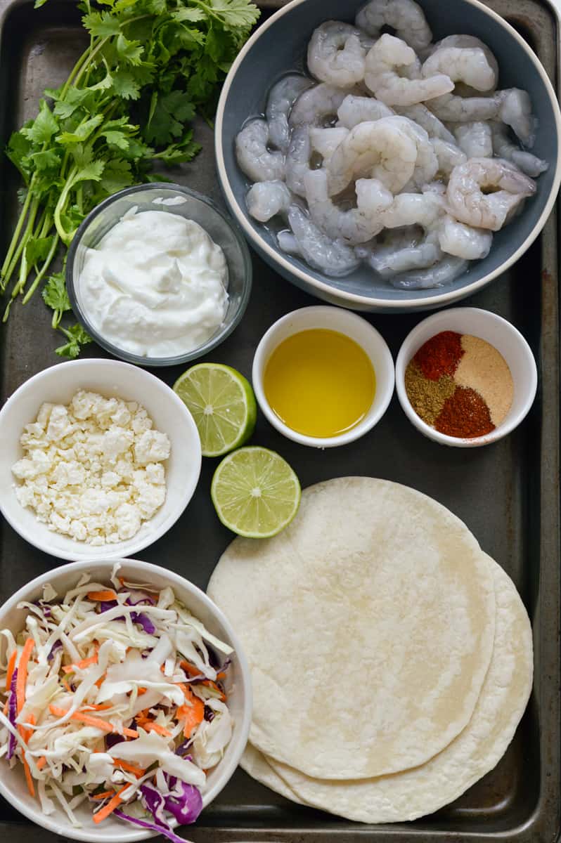 Ingredients for air fryer shrimp tacos including veggies, shrimp, tortillas and Greek yogurt.