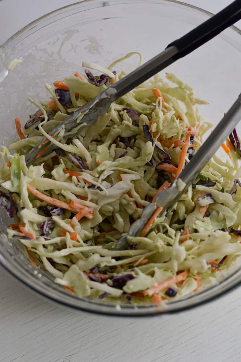 Mixing coleslaw with salad dressing.