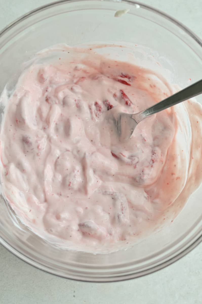 Mixing strawberries and yogurt together.