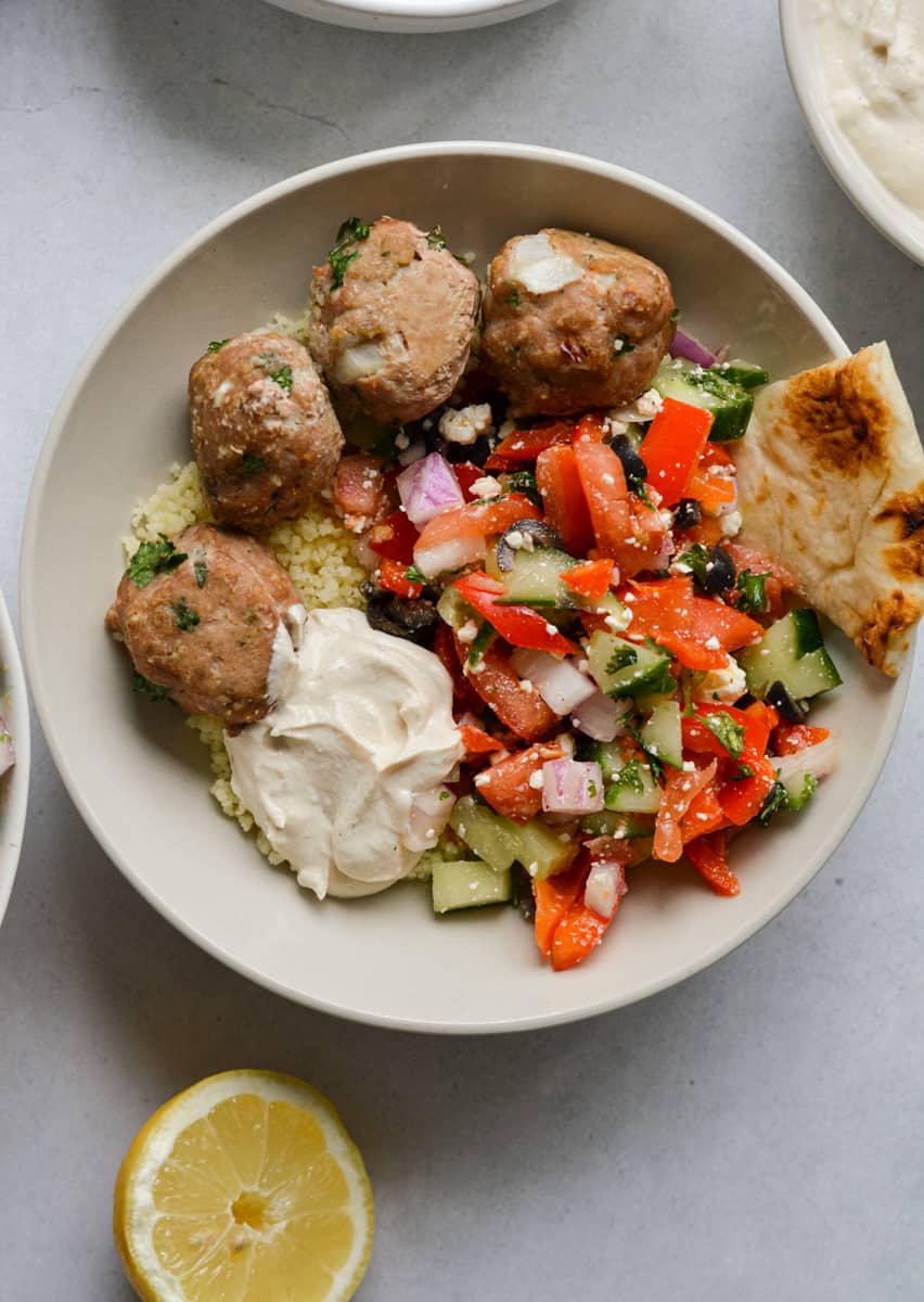 Mediterranean grain bowls with greek turkey feta meatballs, cucumber salad, tahini yogurt and pita.