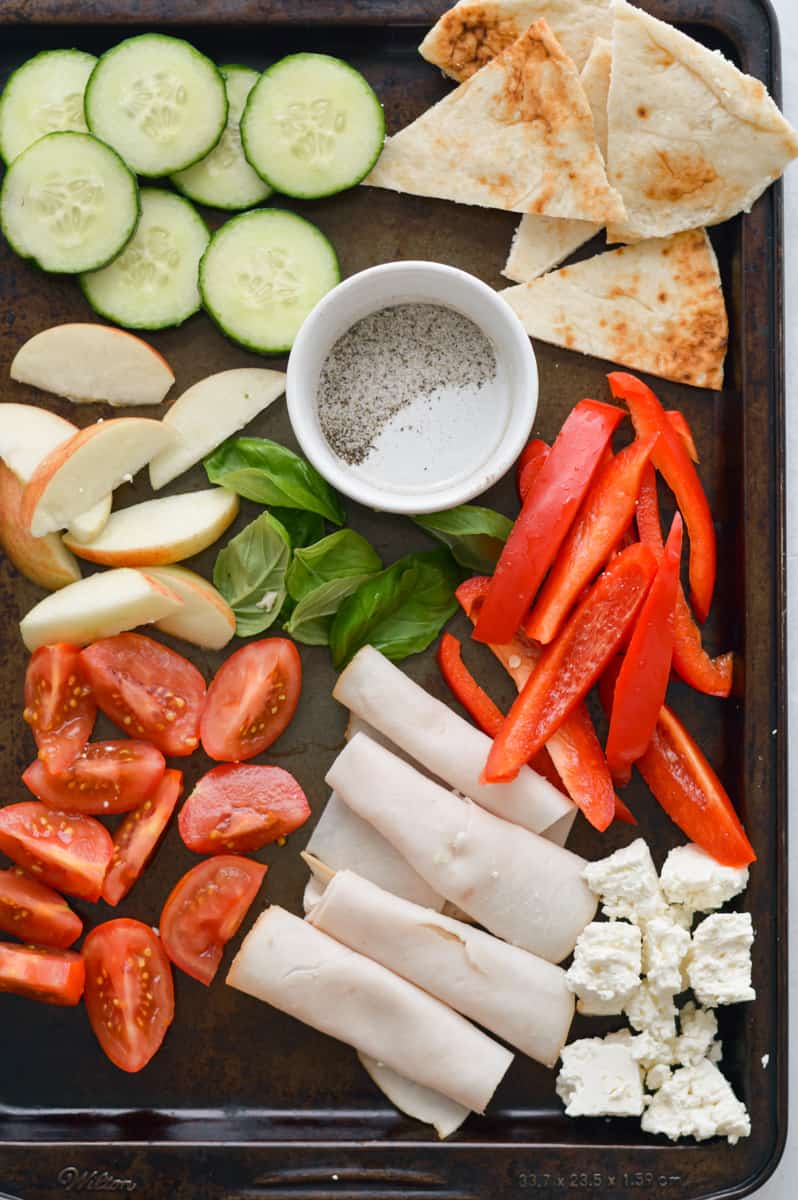 Ideas for snack plate ingredients including cucumbers, apples, tomatoes, turkey, cheese and pita.