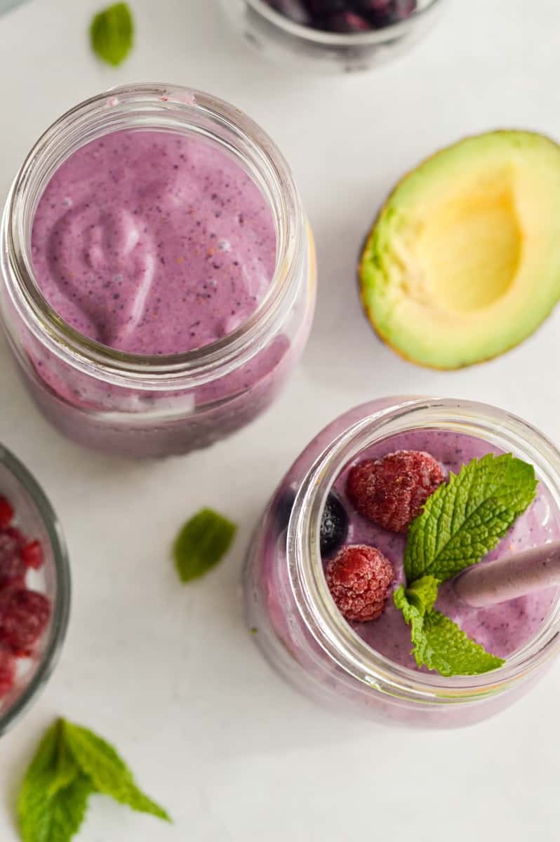 Topping high fiber smoothies with mint leaves and fresh berries.
