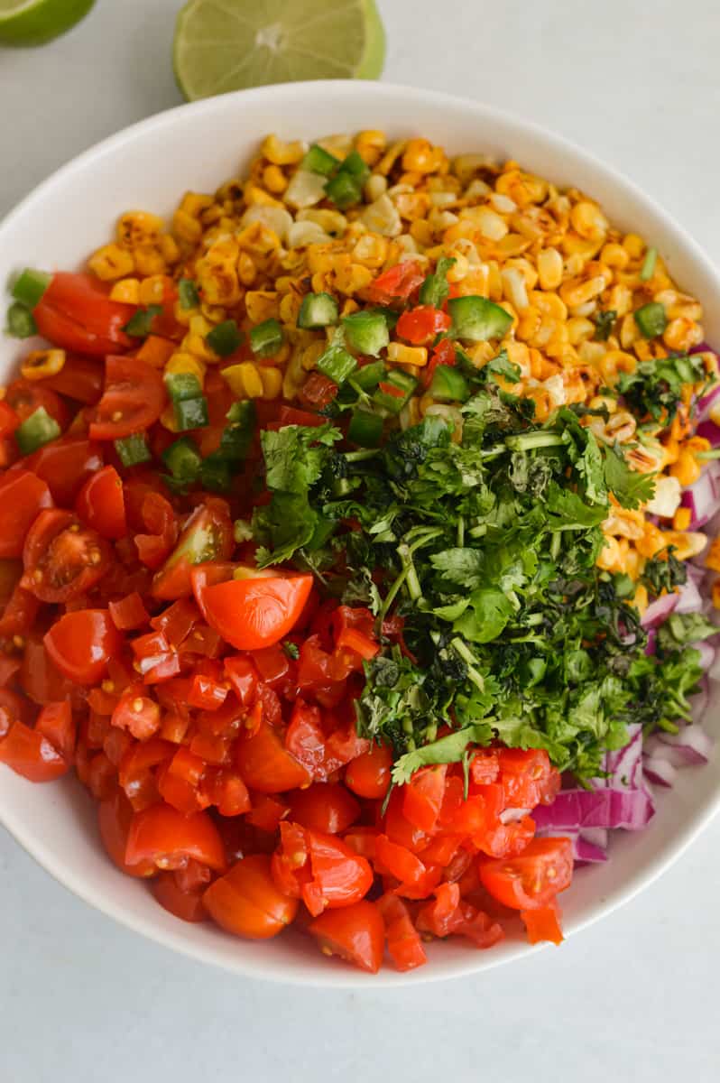Adding salsa ingredients to a bowl.