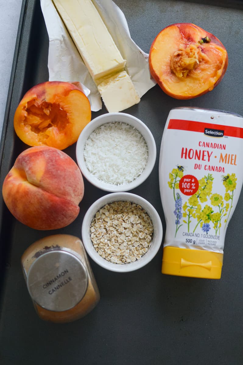 Ingredients including oats, honey, peaches, coconut, cinnamon and butter.
